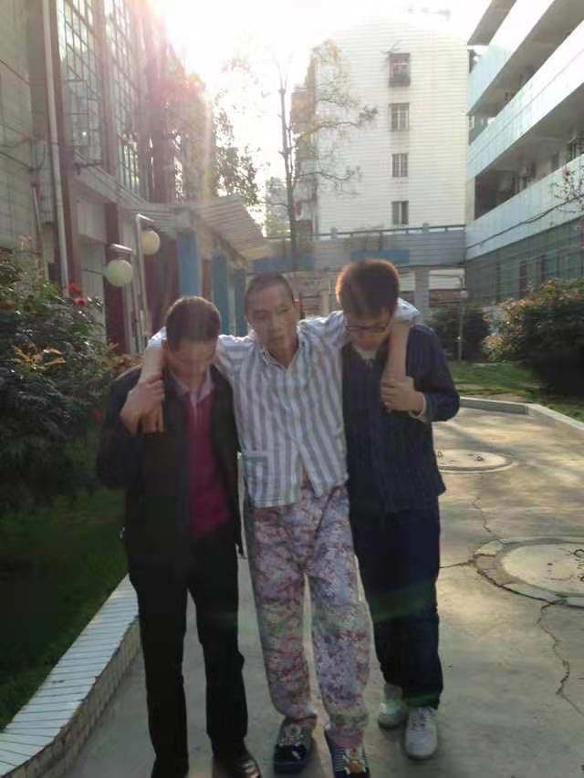 术后康复期间，韦捍东由儿子与侄子搀扶艰难行走